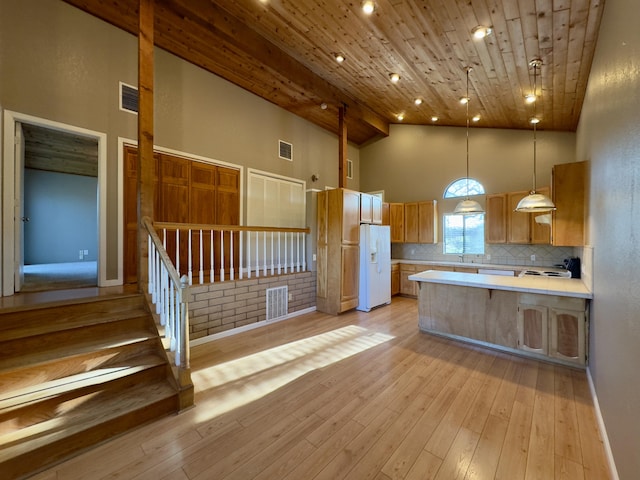 1020 Gibralter Rd, Redding, CA 96003 - kitchen featuring white fridge with ice dispenser, high vaulted ceiling, light countertops, a peninsula, and backsplash