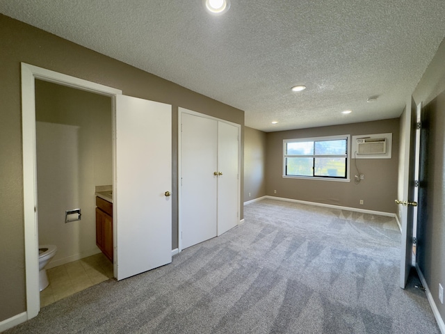 1020 Gibralter Rd, Redding, CA 96003 - unfurnished bedroom featuring an AC wall unit, a textured ceiling, light colored carpet, connected bathroom, and recessed lighting