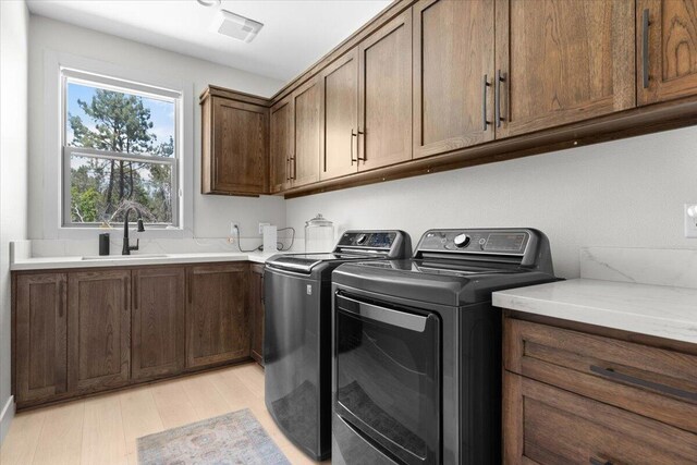 16520 Blarney Ln, Redding, CA 96001 - laundry area with washer and dryer, light wood finished floors, and cabinet space