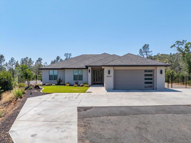 16520 Blarney Ln, Redding, CA 96001 - view of front of house featuring a garage, concrete driveway, stucco siding, and roof with shingles