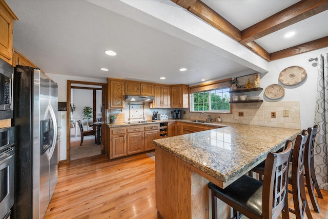 19396 Natalie Way, Redding, CA 96003 - kitchen featuring appliances with stainless steel finishes, a peninsula, light wood-style flooring, tasteful backsplash, and recessed lighting