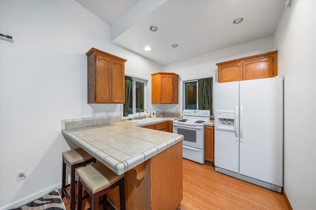 19396 Natalie Way, Redding, CA 96003 - kitchen featuring white appliances, a peninsula, brown cabinetry, light wood-style flooring, and recessed lighting