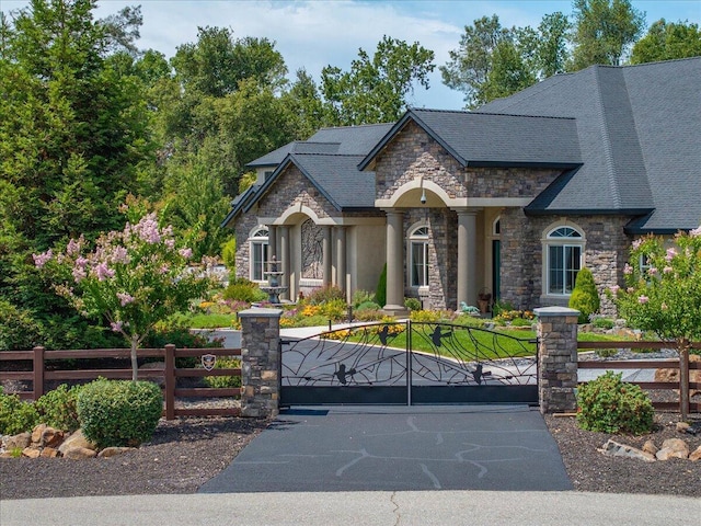 19580 Mockingbird Ln, Redding, CA 96002 - view of front of house featuring stone siding, a fenced front yard, and a gate