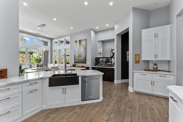 19580 Mockingbird Ln, Redding, CA 96002 - kitchen with white cabinetry, light stone counters, backsplash, light wood-style flooring, and dishwasher