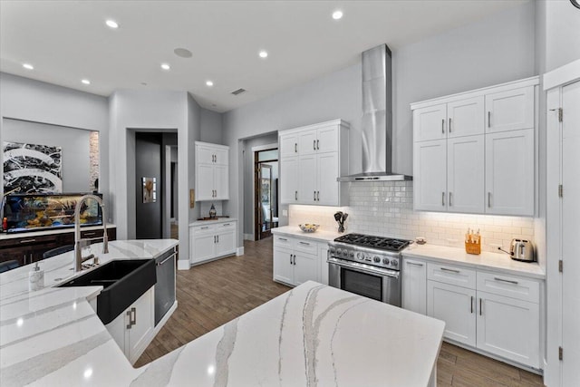 19580 Mockingbird Ln, Redding, CA 96002 - kitchen with wall chimney range hood, appliances with stainless steel finishes, backsplash, white cabinets, and wood finished floors