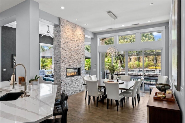 19580 Mockingbird Ln, Redding, CA 96002 - dining space featuring wood-type flooring, a stone fireplace, ceiling fan, a towering ceiling, and recessed lighting