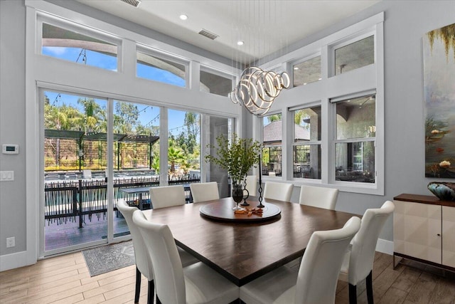 19580 Mockingbird Ln, Redding, CA 96002 - dining room featuring wood finished floors, a chandelier, recessed lighting, and a towering ceiling