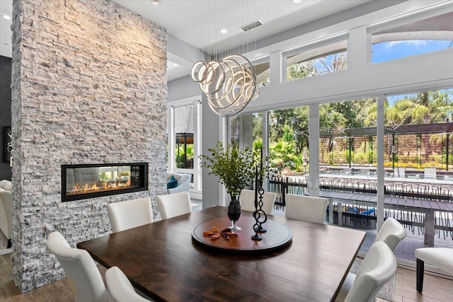 19580 Mockingbird Ln, Redding, CA 96002 - dining area featuring healthy amount of natural light, wood finished floors, a multi sided fireplace, recessed lighting, and a high ceiling