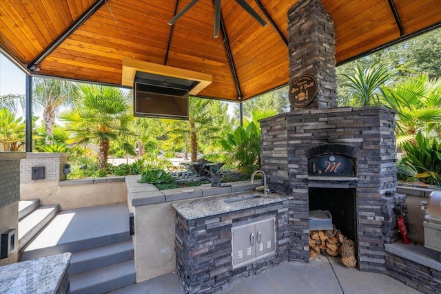 19580 Mockingbird Ln, Redding, CA 96002 - view of patio / terrace with an outdoor kitchen, a gazebo, and an outdoor stone fireplace