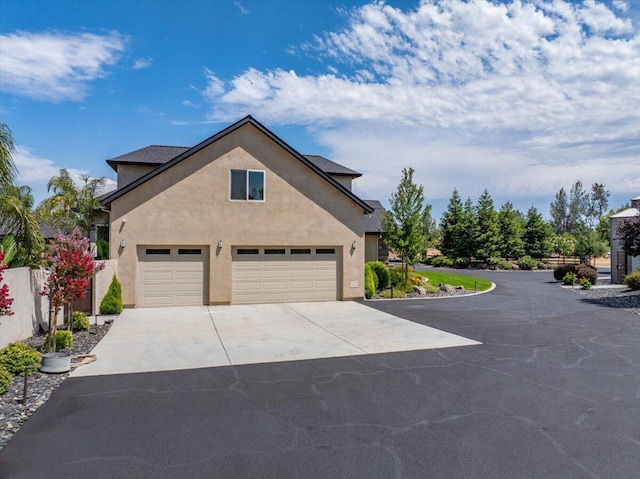 19580 Mockingbird Ln, Redding, CA 96002 - view of property exterior featuring driveway, stucco siding, and an attached garage