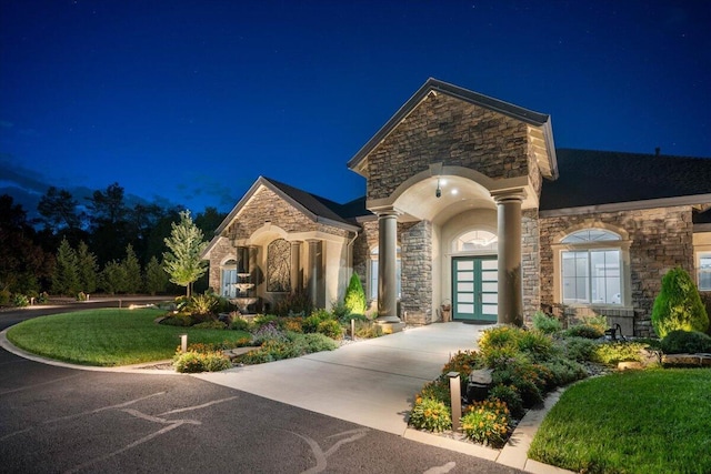 19580 Mockingbird Ln, Redding, CA 96002 - french country style house with stone siding, french doors, concrete driveway, and a lawn
