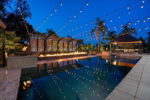 19580 Mockingbird Ln, Redding, CA 96002 - pool at twilight featuring a gazebo, a pool with connected hot tub, and a patio