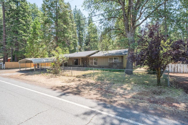 37347 Cypress Ave, Burney, CA 96013 - ranch-style home featuring stone siding, a carport, a fenced front yard, and driveway