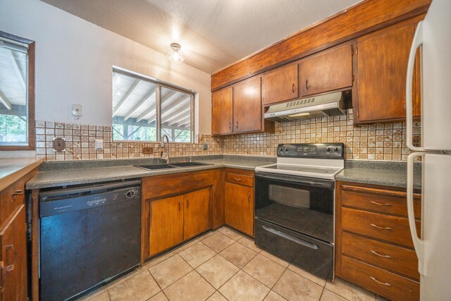 37347 Cypress Ave, Burney, CA 96013 - kitchen with electric range oven, black dishwasher, under cabinet range hood, freestanding refrigerator, and light tile patterned flooring