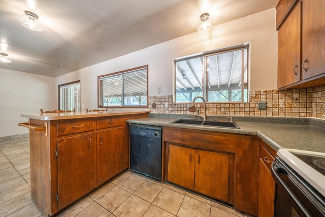 37347 Cypress Ave, Burney, CA 96013 - kitchen with black dishwasher, tasteful backsplash, brown cabinets, light tile patterned floors, and a peninsula