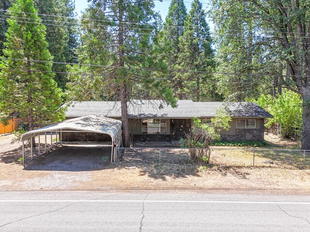 37347 Cypress Ave, Burney, CA 96013 - view of front of home featuring a carport, driveway, a fenced front yard, and stone siding