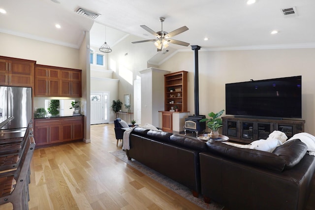 3010 Mateo Ct, Anderson, CA 96007 - living area featuring a wood stove, a ceiling fan, high vaulted ceiling, light wood finished floors, and crown molding