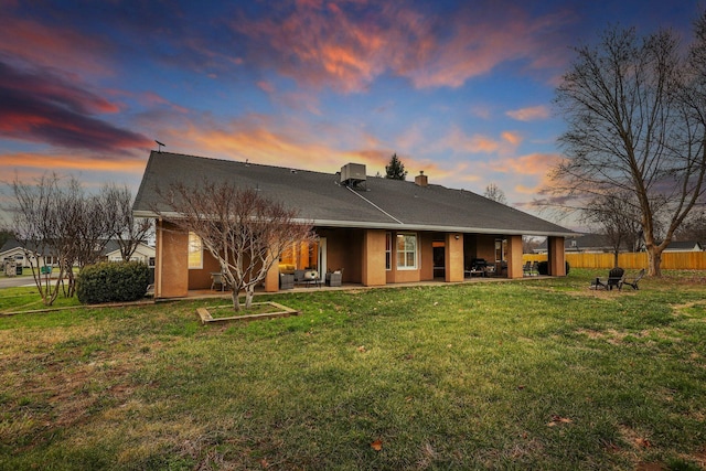 3010 Mateo Ct, Anderson, CA 96007 - back of house at dusk featuring a patio, a chimney, and stucco siding