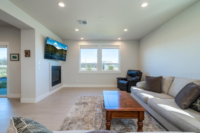 6538 Bandito Dr, Redding, CA 96003 - living room featuring healthy amount of natural light, recessed lighting, light wood-style flooring, and a glass covered fireplace