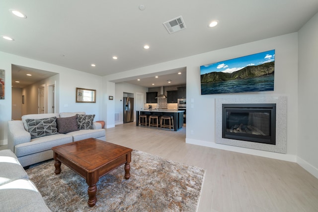 6538 Bandito Dr, Redding, CA 96003 - living area featuring light wood-style flooring, a glass covered fireplace, and recessed lighting