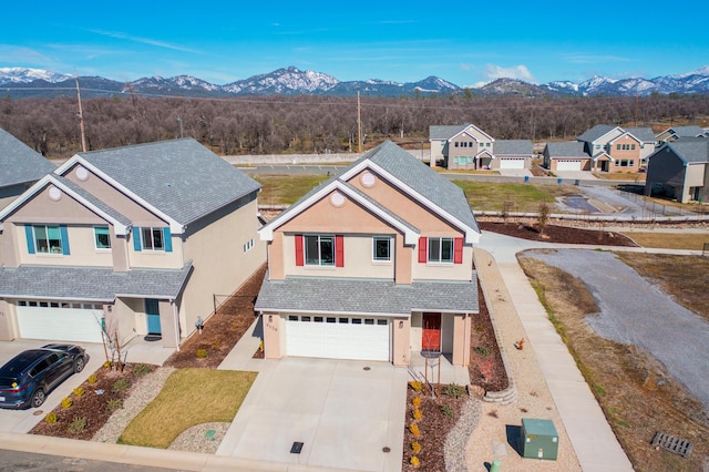 6538 Bandito Dr, Redding, CA 96003 - view of front facade with stucco siding, a garage, driveway, a mountain view, and a shingled roof