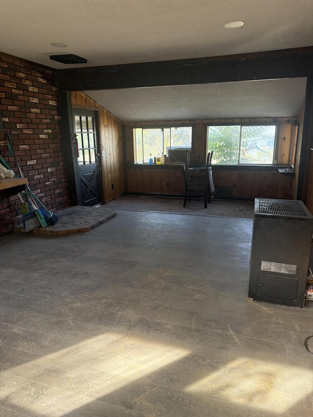 3400 Beacon Dr, Anderson, CA 96007 - unfurnished living room featuring wooden walls, plenty of natural light, and concrete flooring