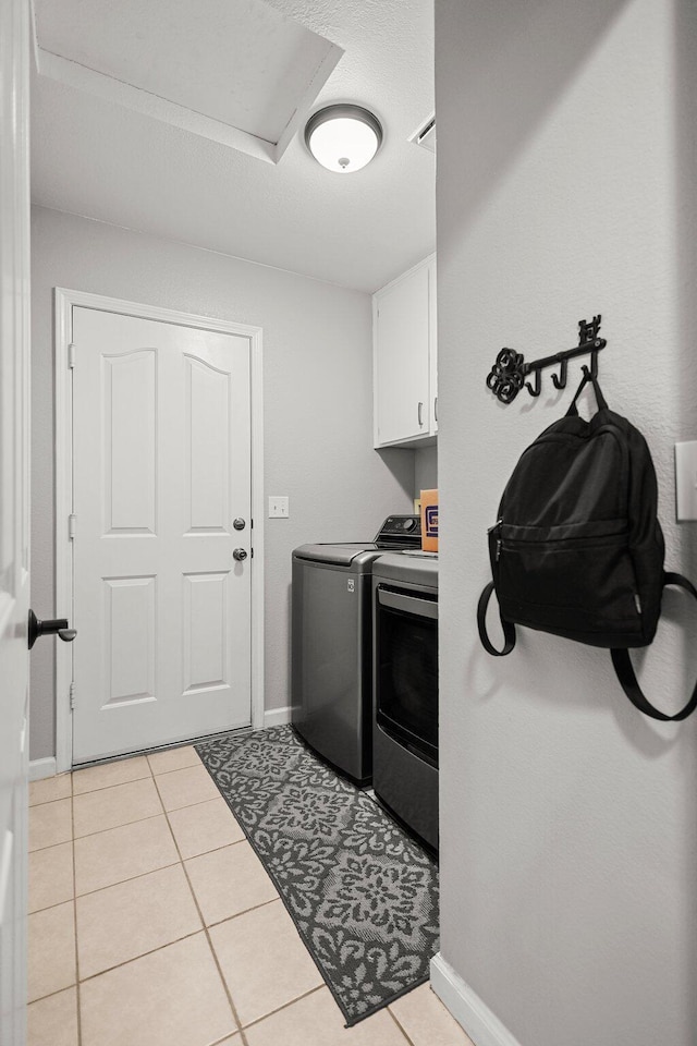 1870 Trumpet Dr, Redding, CA 96003 - laundry room with cabinet space, washing machine and clothes dryer, and light tile patterned flooring
