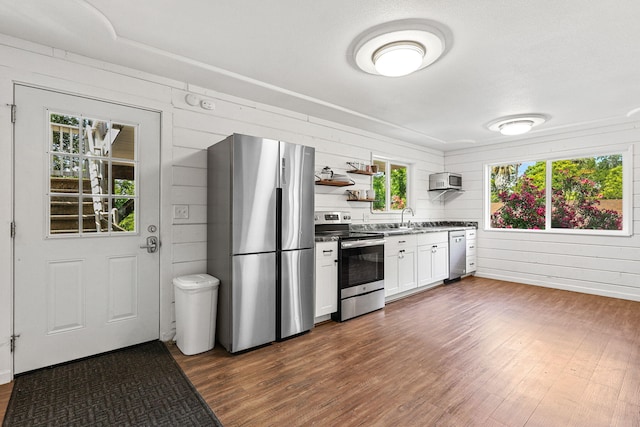 1575 Fig Ave, Redding, CA 96001 - kitchen with stainless steel appliances, dark wood-style floors, open shelves, white cabinetry, and wooden walls