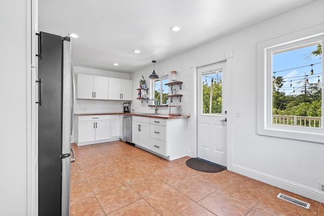1575 Fig Ave, Redding, CA 96001 - kitchen with appliances with stainless steel finishes, white cabinets, recessed lighting, light tile patterned flooring, and hanging light fixtures