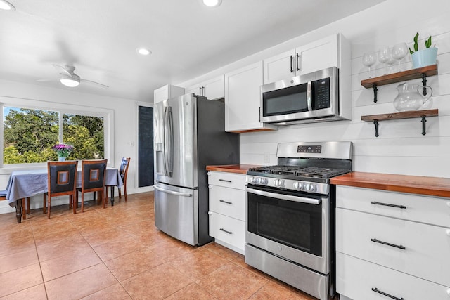 1575 Fig Ave, Redding, CA 96001 - kitchen with stainless steel appliances, wooden counters, recessed lighting, light tile patterned flooring, and white cabinetry