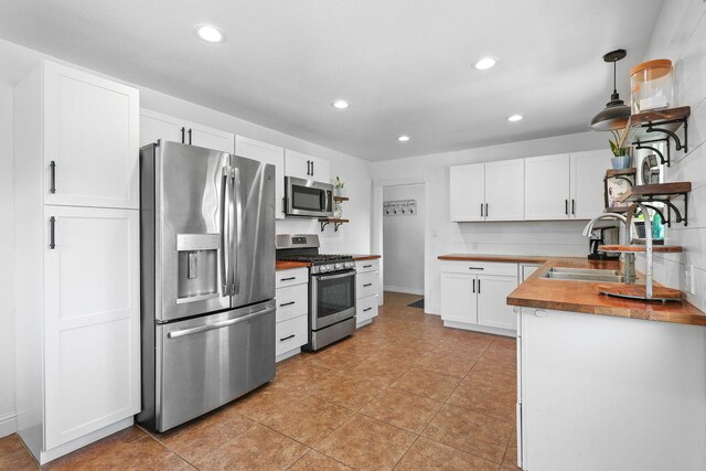 1575 Fig Ave, Redding, CA 96001 - kitchen featuring stainless steel appliances, recessed lighting, white cabinetry, light tile patterned flooring, and butcher block countertops