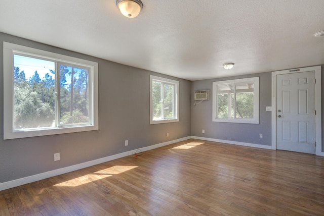 12194 Lake Blvd, Redding, CA 96001 - unfurnished room with wood finished floors, a wall mounted air conditioner, a textured ceiling, and a smoke detector
