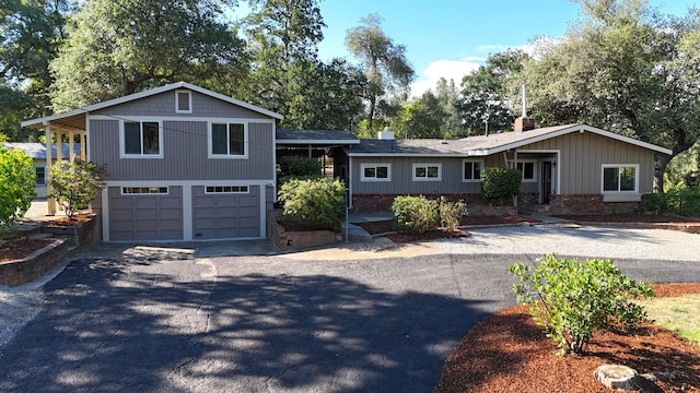 12194 Lake Blvd, Redding, CA 96001 - view of front of house with driveway, an attached garage, a chimney, and brick siding