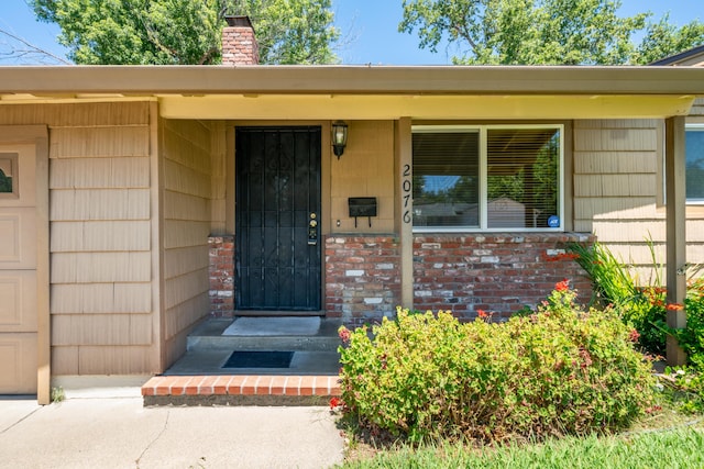 2076 Merle Dr, Redding, CA 96001 - property entrance with a chimney and brick siding