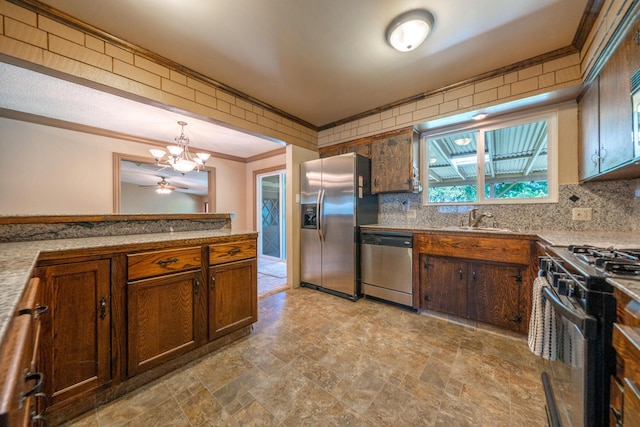 2076 Merle Dr, Redding, CA 96001 - kitchen with stainless steel appliances, ornamental molding, stone finish flooring, a chandelier, and decorative backsplash