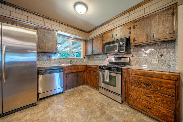 2076 Merle Dr, Redding, CA 96001 - kitchen featuring appliances with stainless steel finishes, stone finish flooring, tasteful backsplash, and brown cabinets