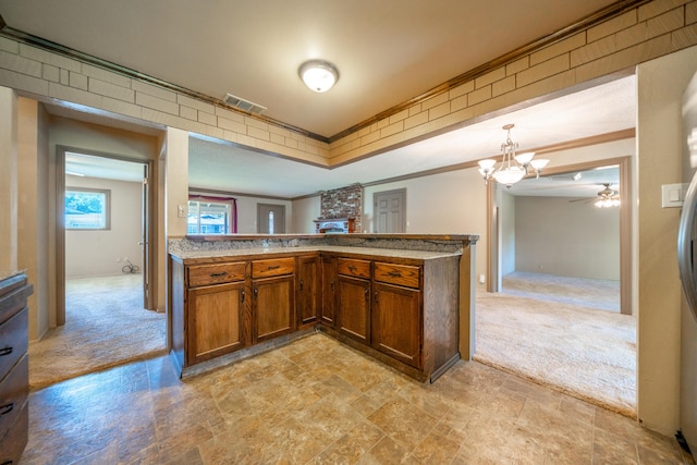 2076 Merle Dr, Redding, CA 96001 - kitchen featuring ornamental molding, light carpet, ceiling fan, a peninsula, and decorative light fixtures