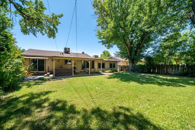 2076 Merle Dr, Redding, CA 96001 - rear view of house featuring a hot tub, a fenced backyard, a patio, and stucco siding