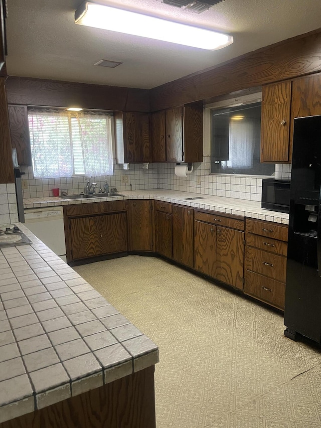 1110 Dusty Ln, Redding, CA 96002 - kitchen featuring tile counters, black appliances, backsplash, and light floors