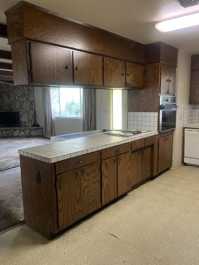 1110 Dusty Ln, Redding, CA 96002 - kitchen featuring black oven, dishwasher, tile counters, and tasteful backsplash