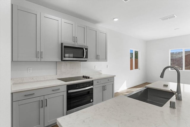 876 Wind Cove Dr, Redding, CA 96001 - kitchen with stainless steel appliances, gray cabinets, light stone countertops, decorative backsplash, and recessed lighting