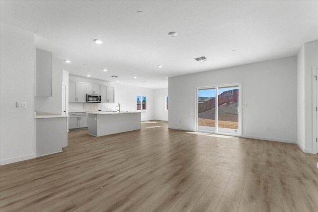876 Wind Cove Dr, Redding, CA 96001 - unfurnished living room with light wood-style floors and recessed lighting
