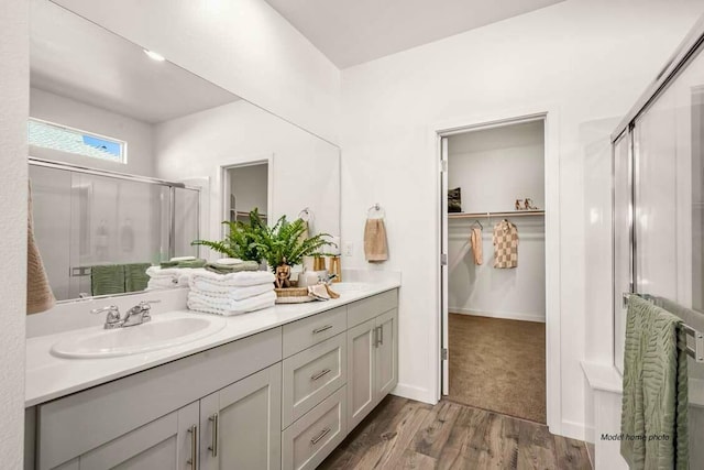 876 Wind Cove Dr, Redding, CA 96001 - bathroom with a shower stall, double vanity, a walk in closet, and wood finished floors