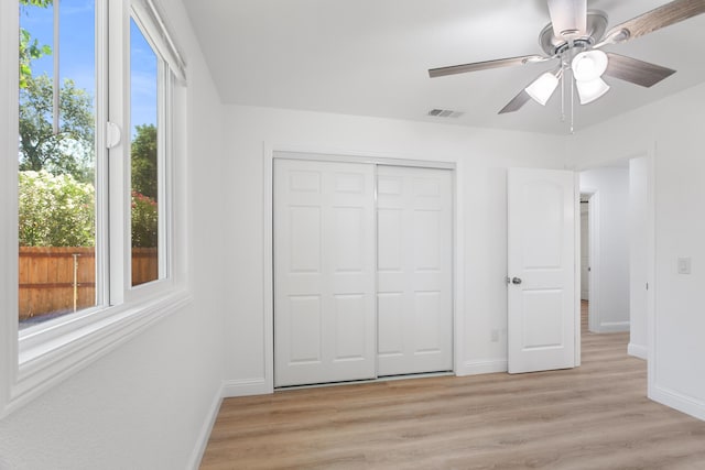2445 Toyon St, Anderson, CA 96007 - unfurnished bedroom with light wood-style floors, multiple windows, a closet, and a ceiling fan