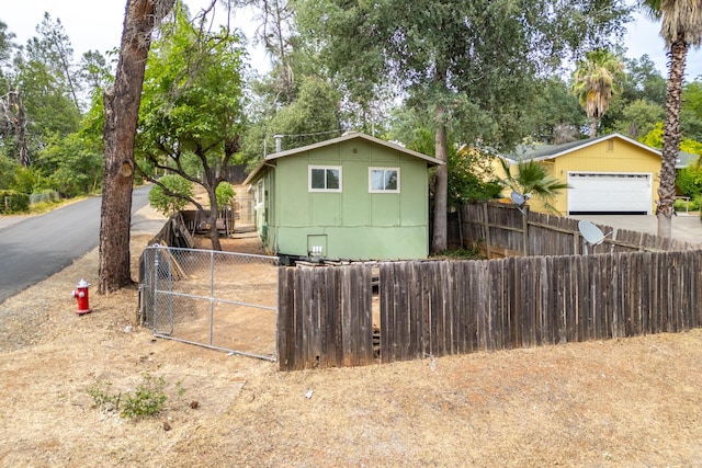 1535 Provo Ave, Shasta Lake, CA 96019 - view of front facade with a garage, a gate, driveway, and view of wooded area