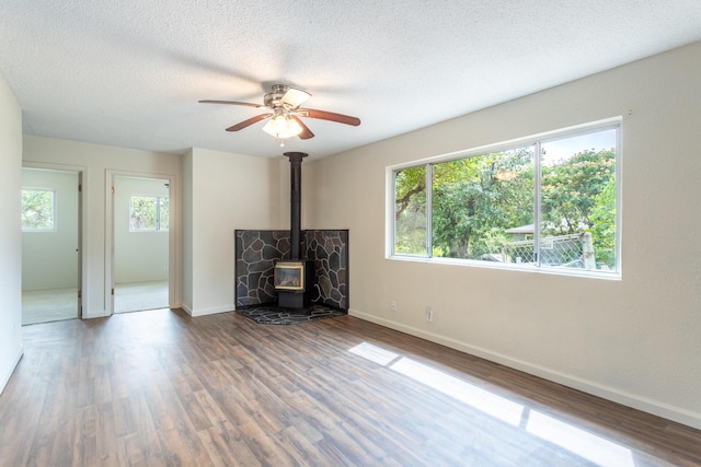 1535 Provo Ave, Shasta Lake, CA 96019 - unfurnished living room with a wood stove, wood finished floors, ceiling fan, and a textured ceiling