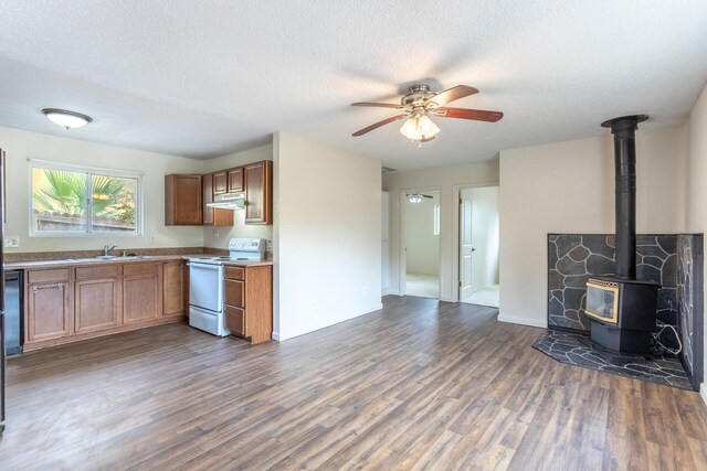 1535 Provo Ave, Shasta Lake, CA 96019 - kitchen with white range with electric stovetop, under cabinet range hood, brown cabinetry, dark wood-style floors, and a textured ceiling