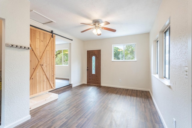 1535 Provo Ave, Shasta Lake, CA 96019 - foyer entrance featuring a barn door, dark wood-type flooring, a ceiling fan, and a textured wall