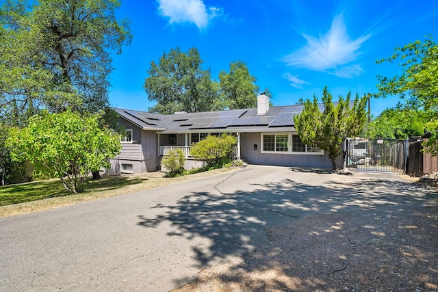 1448 Carter Way, Redding, CA 96002 - ranch-style house featuring a chimney, solar panels, a gate, and asphalt driveway