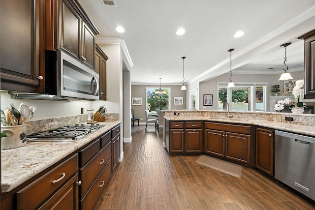 2110 Cilantro Dr, Redding, CA 96003 - kitchen with stainless steel appliances, ornamental molding, dark brown cabinets, dark wood finished floors, and hanging light fixtures